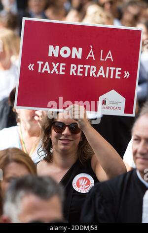 A woman holds a placard reading 'No the retirement tax' as protesters demonstrate against the pension reform in Paris on September 16, 2019. Several thousand lawyers, accompanied by healthcare professionals (doctors, nurses etc.) or air transport (pilots, hostesses, stewards), all opposed to the 'universal system' of pensions wanted by the government, began to protest to defend their 'autonomous regimes.'. Photo by Raphael Lafargue/ABACAPRESS.COM Stock Photo