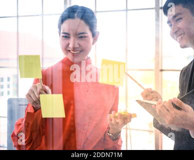 Business couple   meeting at office and use post it notes to share idea. Business teamwork concept. Stock Photo
