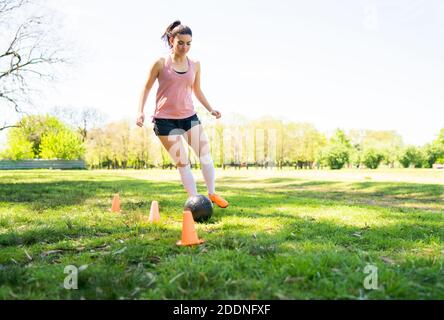 Young female soccer player practicing on field. Stock Photo