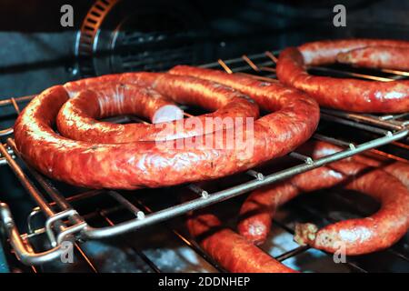 Racks of ham sausages drying in an oven after being cooked Stock Photo