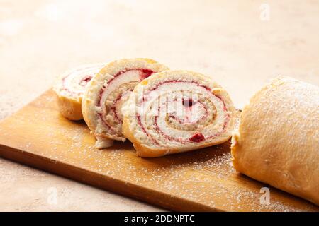 Baked biscuit swiss roll dessert with fruits and cream chopped on pieces Stock Photo