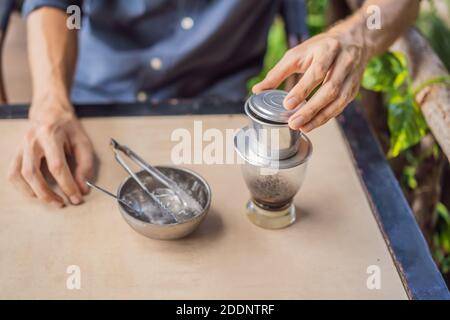 Caucasian man and traditional drip brewed Vietnamese coffee from a phin filter Stock Photo