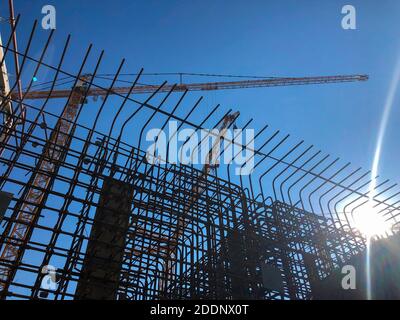 Tower cranes against blue sky. Lifting machinery at construction site Stock Photo
