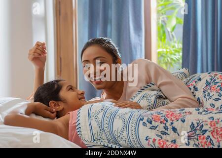 Playful morning, mother and daughter in bed Stock Photo