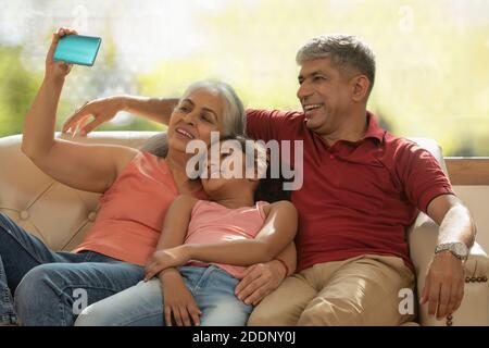 Grand mother taking a selfie of grand daughter and her husband Stock Photo