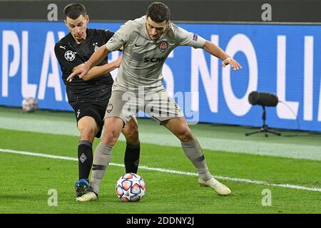 Moenchengladbach, Germany. 25th Nov, 2020. Stefan Lainer (L) of Moenchengladbach vies with Junior Moraes of Donetsk during the UEFA Champions League Group B football match between Borussia Moenchangladbach and FC Shakhtar Donetsk in Moenchangladbach, Germany, Nov. 25, 2020. Credit: Ulrich Hufnagel/Xinhua/Alamy Live News Stock Photo