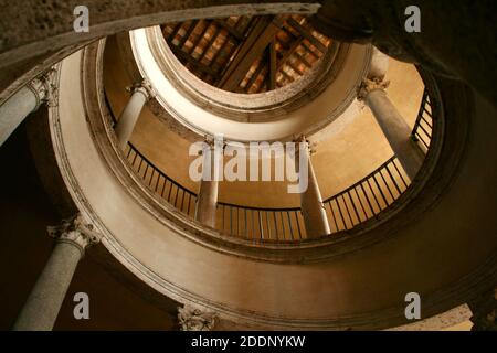 Spiral rounded ramp stairs. Into the dark, into the light. Rising up, going down. Mystic lighting. Ancient historic walls and columns. Stock Photo