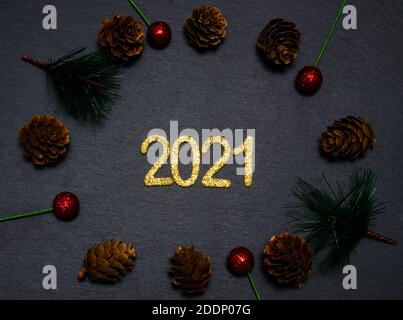 Happy New year 2021. Golden digits 2021 flat lay with copy space on black background. 2021 numbers with Christmas natural decorations Stock Photo