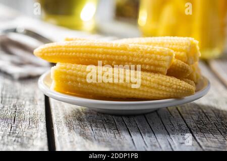 Pickled young baby corn cobs on a plate. Stock Photo