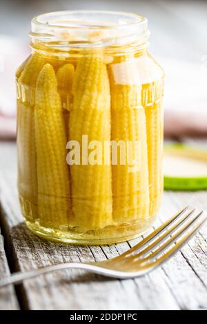 Pickled young baby corn cobs in a jar. Stock Photo