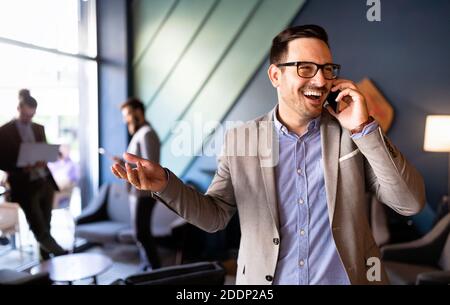 Enjoying his work. Happy young successful businessman talking on the mobile phone Stock Photo
