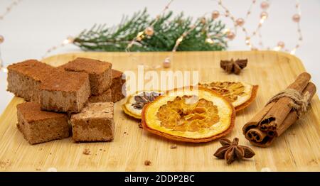 Fragrant spices and homemade marshmallows on a wooden tray, decorated with fir branches and a festive garland. Stock Photo