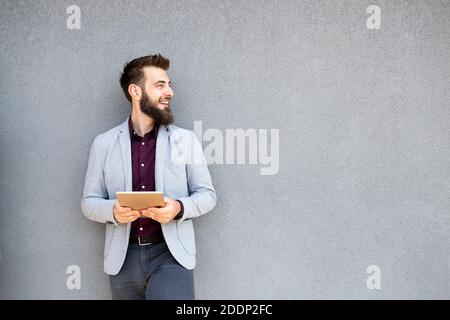 Young businessman holding tablet in hands outdoor Stock Photo