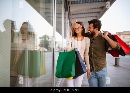 Couple of tourists walking in a city street and shopping, having fun Stock Photo