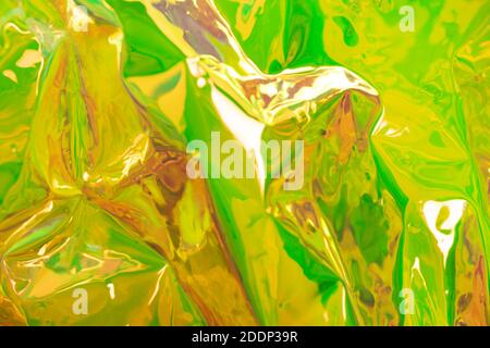 Yellow blurred holographic background. Wrinkled foil texture. Abstract surreal backdrop with soft focus. Stock Photo