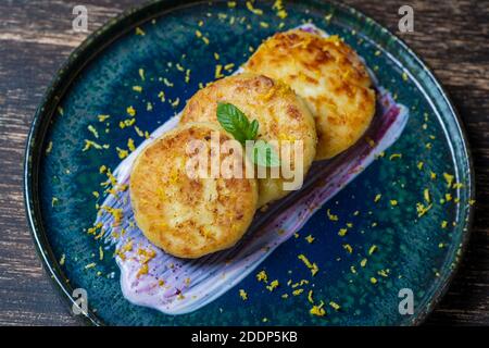 Cheesecakes with mint and sour cream. Delicious dessert, ukrainian food. Close up, top view Stock Photo