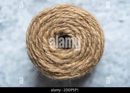 High-quality handmade coil made of natural hemp rope, isolated on a white background. Rustic beige cord made of eco material Stock Photo