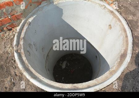 Construction of a septic tank. Large concrete rings embedded in the ground,  from above an open sewer hatch, unprotected by a cover from falling Stock  Photo - Alamy