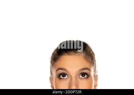 Half portrait of young puzzled woman , looking up on white background Stock Photo