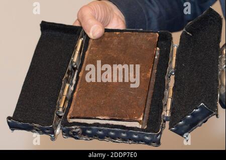 person holding an antiquarian book, which is put in a case, in his hand Stock Photo