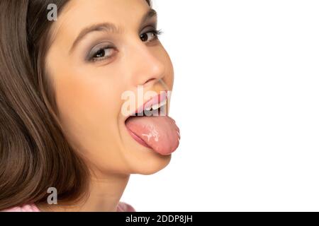 portrait of young woman with tongue out on white background Stock Photo