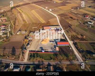 Aerial View Over The Grain Warehouse. Around the Warehouse Large Agricultural Fields. Stock Photo