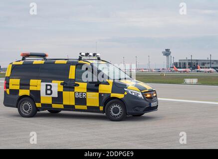 03 November 2020, Brandenburg, Schönefeld: A 'Follow me' vehicle stands on the southern runway against the backdrop of the tower and Terminal 1 of Berlin Brandenburg Airport (BER). Photo: Soeren Stache/dpa-Zentralbild/ZB Stock Photo