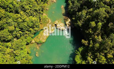 Aerial drone of Tropical Loboc river in the rainforest. Mountain river flows through green forest. Bohol, Philippines. Stock Photo