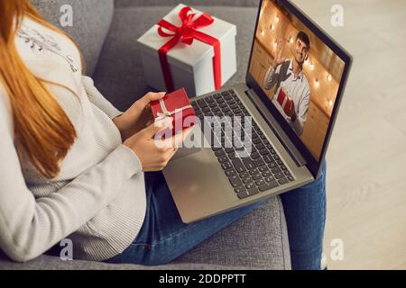 Young happy couple having online date on laptop with showing presents for holiday Stock Photo