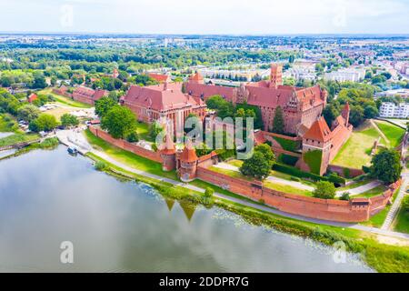 Medieval Malbork (Marienburg) Castle in Poland, main fortress of the Teutonic Knights at the Nogat river. Aerial view in fall in sunset light. Stock Photo