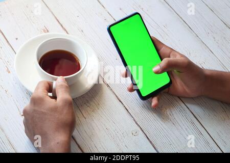 rear view of man hand using smart phone on table  Stock Photo