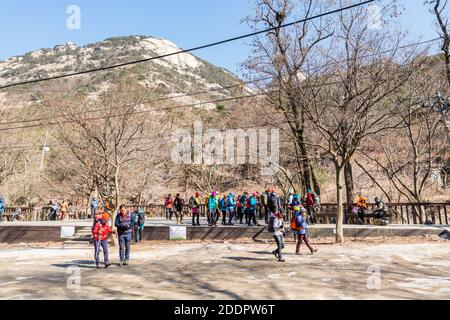 Korean hikers climbing the rock at the Bukhansan Mountain National park in Soeul, South Korea. Stock Photo