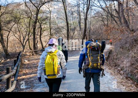 Korean hikers climbing the rock at the Bukhansan Mountain National park in Soeul, South Korea. Stock Photo