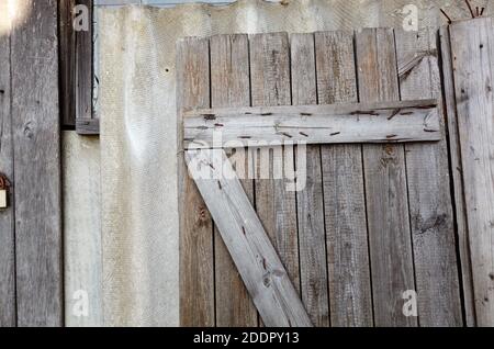 Old wooden removed door on wall. Vintage weathered background Stock Photo