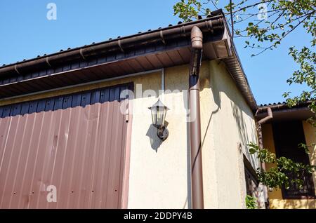 Facade of a suburban garage. Building with downspout and lantern Stock Photo