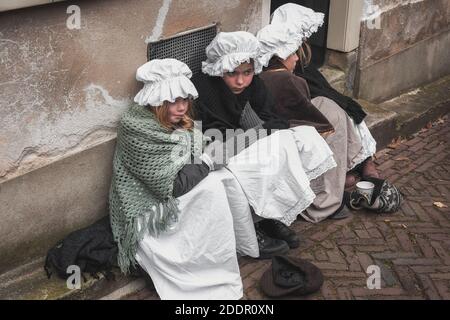 Deventer, Netherlands, December 15, 2018: Four little girls begging on the street during the Dickens Festival in Deventer Stock Photo