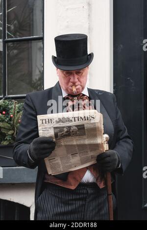 Deventer, Netherlands, December 15, 2018: Man with top hat reading a newspaper during the Dickens festival Stock Photo