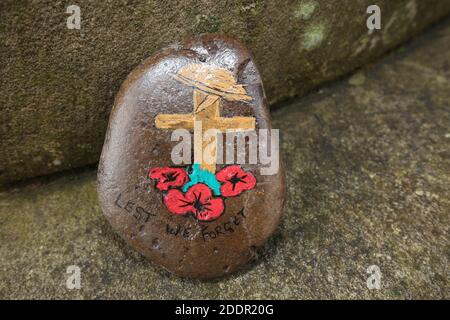 Painted stones depicting scenes from the war to commerate remembrance around stone pillar in Auchinleck Parish Church, Ayrshire, Scotland Stock Photo