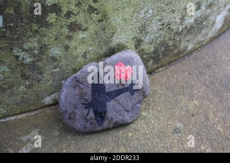 Painted stones depicting scenes from the war to commerate remembrance around stone pillar in Auchinleck Parish Church, Ayrshire, Scotland Stock Photo