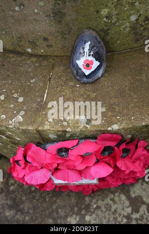 Painted stones depicting scenes from the war to commerate remembrance around stone pillar in Auchinleck Parish Church, Ayrshire, Scotland Stock Photo