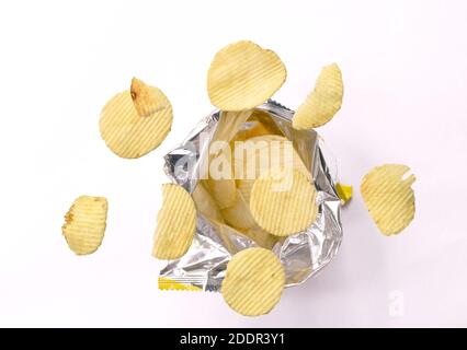 potato chip floating over aluminium foil packaging on white background Stock Photo