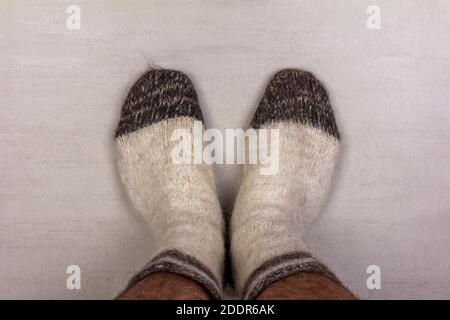men's feet in white knitted wool socks close-up, top view Stock Photo