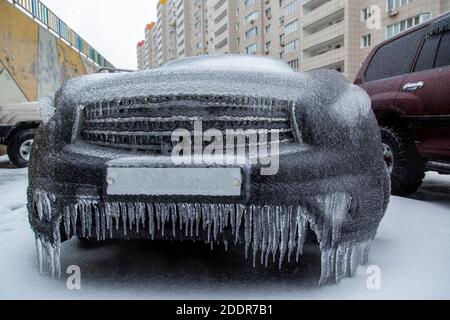 The black SUV is frozen over. Covered all over with a crust of ice after the rain in winter. Stock Photo