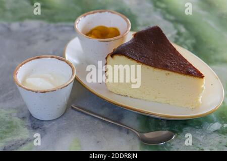 Piece of classic new york cheesecake with sauses on marble table Stock Photo