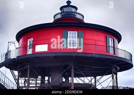 the historic red and black landmark seven foot knoll lighthouse within the inner harbor in baltimore maryland on an overcast day. Stock Photo