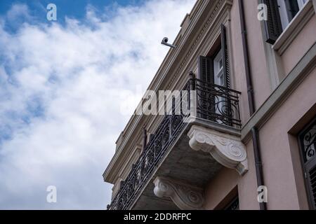 Neoclassical building facade with balcony detail, cloudy sky background, Plaka, Athens Greece. Low angle view Stock Photo