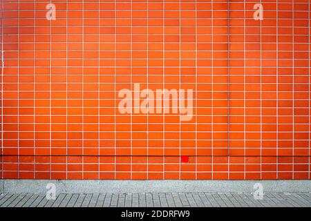 Modern red clay tile wall and a sidewalk. Stock Photo