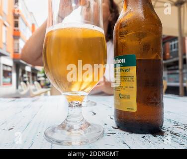 Mature woman drinking Spanish Mahou beer at outdoor cafe/bar in Spain Stock Photo