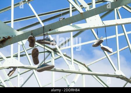 Old trainers, training shoes hanging from steel girders, Stock Photo