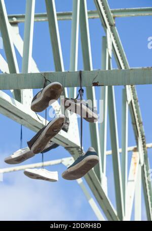 Old trainers, training shoes hanging from steel girders, Stock Photo